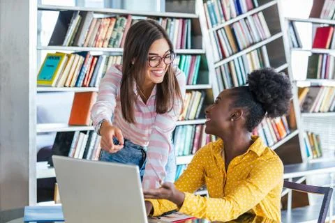 Young professionals work in company, using laptop and tablet. Two women are a Stock Photos