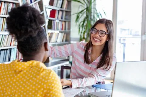 Young professionals work in company, using laptop and tablet. Two women are a Stock Photos
