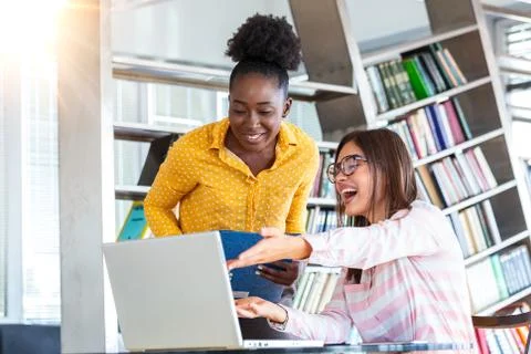 Young professionals work in company, using laptop and tablet. Two women are a Stock Photos