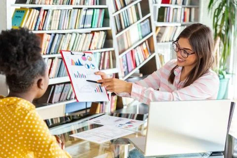 Young professionals work in company, using laptop and tablet. Two women are a Stock Photos