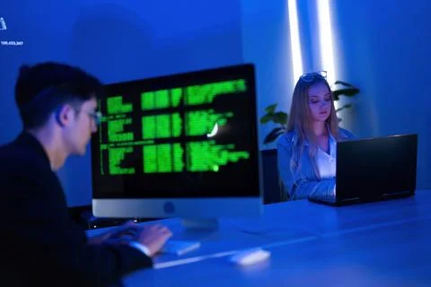 Young professionals working on computer programming in a modern office at nig 写真素材