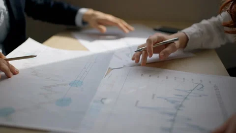 Young professionals working with financial project sitting in workplace in Stock-Footage 90402057