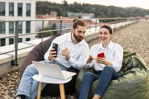 Young professionals working on rooftop with digital devices Stock Photos