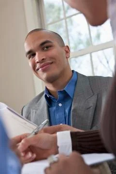Young professionals working together at a table reviewing documents Stock Photos