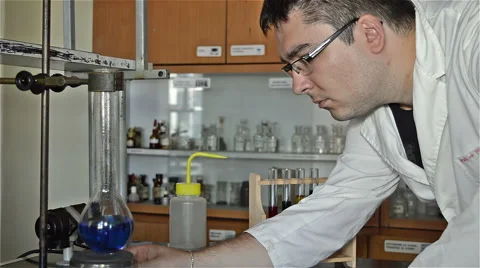 Young Professor Checks the Boiling in the Laboratory Dishes Stock Footage 65029156