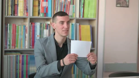 A young professor holds a Blank Sheet in his hand Stock Footage 168937899