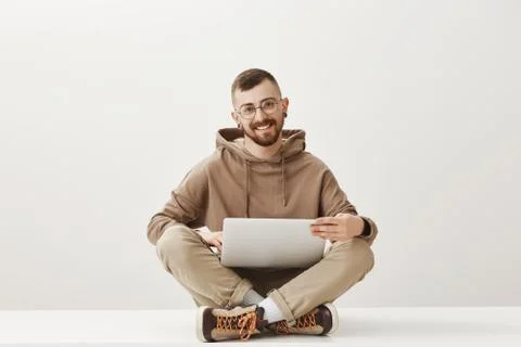 Young program developer curiously listening to his coworker. Pleased happy man 写真素材