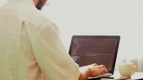 Young programmer coding on a laptop in office Stock Footage 108257238
