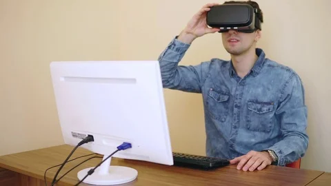 Young programmer experiencing and trying new VR glasses while sitting near his Stock Footage 72887628