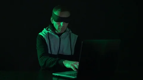 A young programmer in front of a laptop computer is blind, blindfolded typing Stock Footage 123898202
