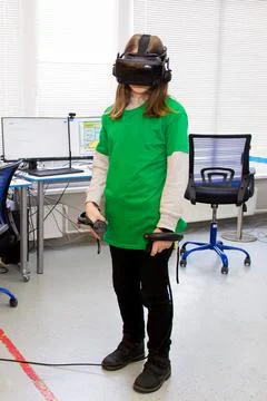 Young programmer girl in a virtual reality helmet. Stock-Fotos
