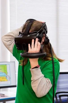 Young programmer girl in a virtual reality helmet. Stock-Fotos