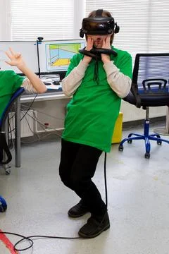 Young programmer girl in a virtual reality helmet. Stock Photos