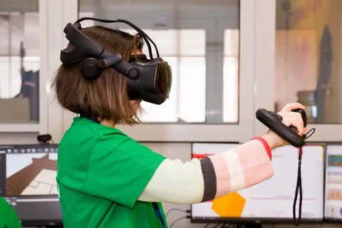 Young programmer girl in a virtual reality helmet. Stock-Fotos