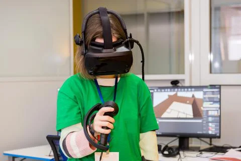 Young programmer girl in a virtual reality helmet. Stock Photos