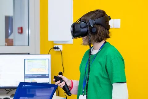 Young programmer girl in a virtual reality helmet. Stock Photos