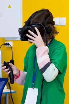 Young programmer girl in a virtual reality helmet. Stock Photos