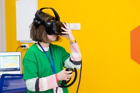 Young programmer girl in a virtual reality helmet. Stock Photos