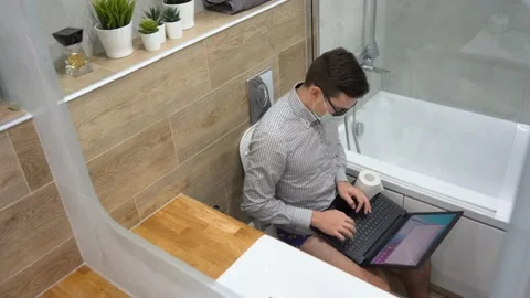 Young programmer man wear shorts, black glasses, face mask, works remote at home Stock Footage 131464910
