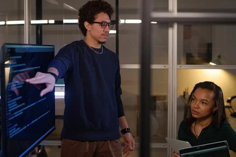 Young Programmer Showing Code To Colleagues Stock Photos