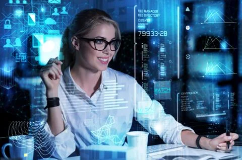 Young programmer smiling while looking at the screen and making notes Stock-Fotos