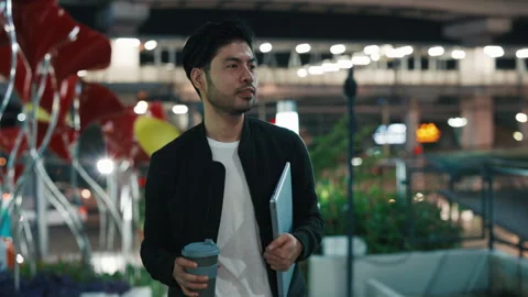 Young programmer strolling in megapolis and keeping laptop Stock-Footage 309556335