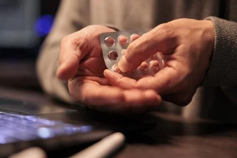 Young programmer taking pills and vitamins from foil Stock Photos