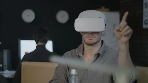 Young programmer using vr glasses. Designer testing 3D game in night office Stock Footage 111574264