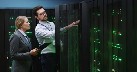 Young programmer in white shirt approaches server cabinet, opens and shows it to 库存影片 152056342