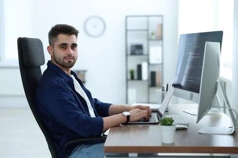 Young programmer working at desk in office Stock Photos