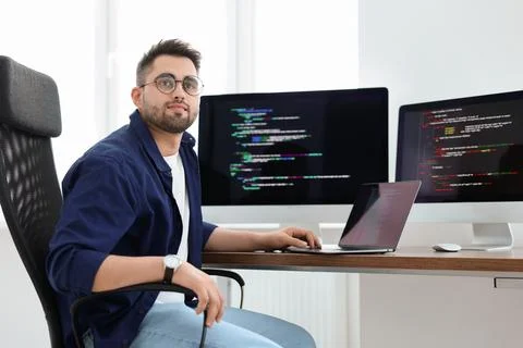Young programmer working at desk in office Stock Photos