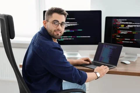 Young programmer working at desk in office Stock Photos