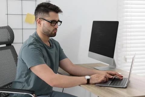 Young programmer working at desk in office 库存照片