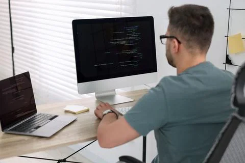 Young programmer working at desk in office Foto stock