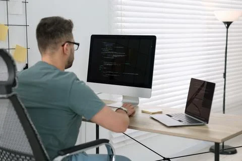 Young programmer working at desk in office Foto stock