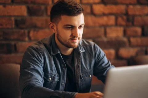 Young programmer working on a laptop in a cafe Stockfoto's