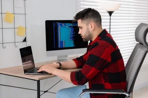 Young programmer working with laptop in office Stock Photos