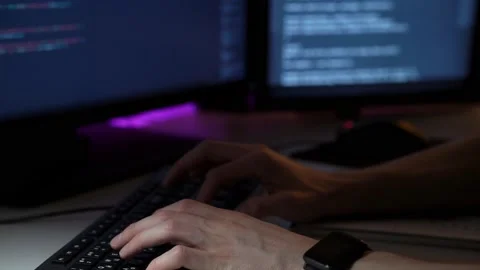 Young programmer works in front of computer typing on keyboard and writing notes Stock Footage 151720017