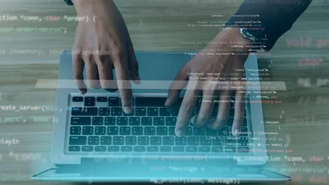 Young programmer writing program code sitting at the workplace with laptop .. 库存照片