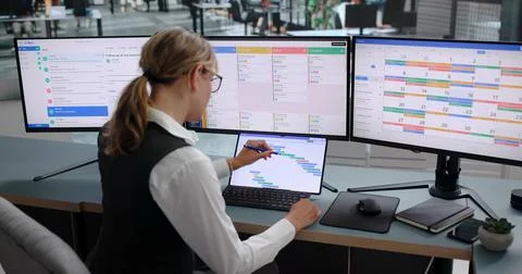 Young Project Manager Updates Schedule While Reviewing Team Progress Data. Stock Photos