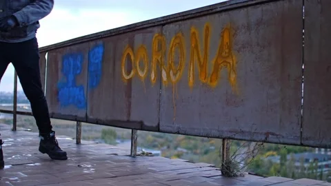 Young protester in denim jacket goes out after making graffiti corona Stock Footage 143349817