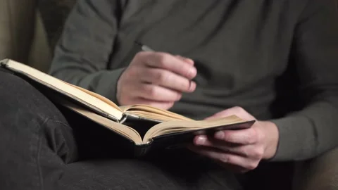 Young psychologist making an entry in a journal while receiving a patient. Stock Footage 235529993