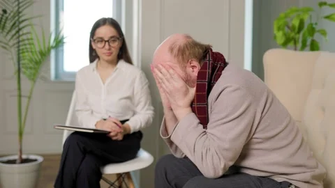 Young psychologist taking notes while consulting depressed caucasian patient Stock Footage 230522128