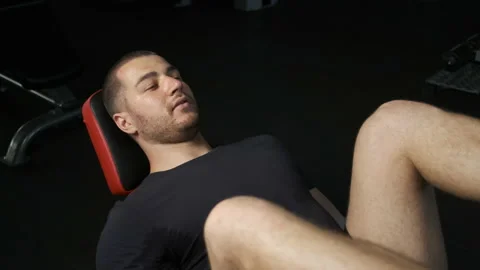 A young pumped-up athlete does another leg exercise in the gym in preparation Stock Footage 135306736