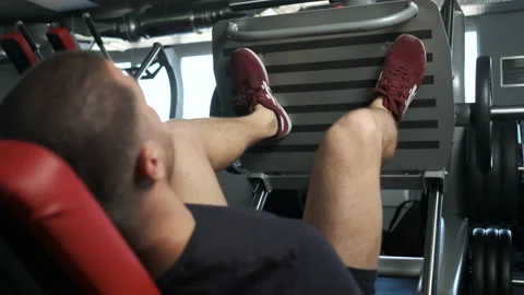 A young pumped-up athlete does another leg exercise in the gym in preparation Stock Footage 136176513