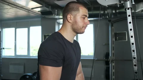 Young pumped-up athlete doing another biceps exercise at the gym in preparation Stock Footage 134909861