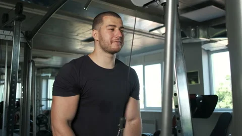 Young pumped-up athlete doing another biceps exercise at the gym in preparation Stock Footage 136819472