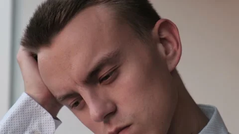 Young puzzled man scratching his head thinking about getting out of situation Stock Footage 215030938