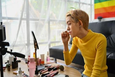 Young queer man beauty make up artist or vlogger recording makeup tutorial in Foto stock