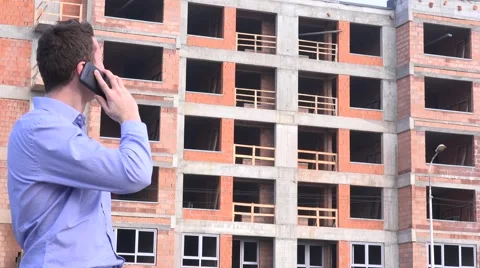 Young real estate developer talking on mobile phone to material suppliers 4K Stock Footage 58513761
